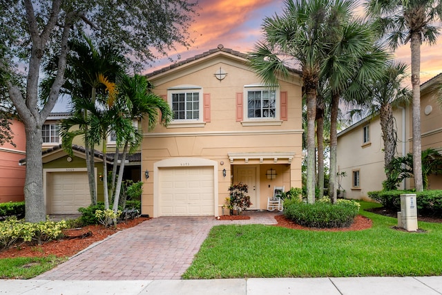 view of front of house featuring a garage and a lawn