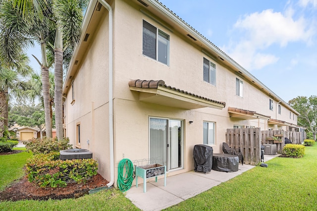 rear view of house featuring central air condition unit, a yard, and a patio