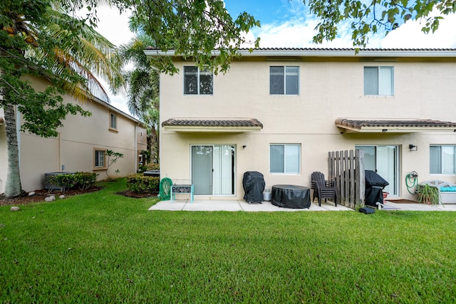 back of house featuring central air condition unit, a lawn, and a patio area