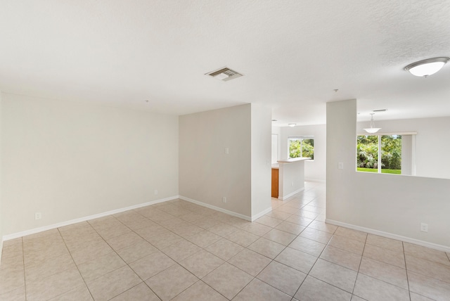 tiled spare room featuring a textured ceiling