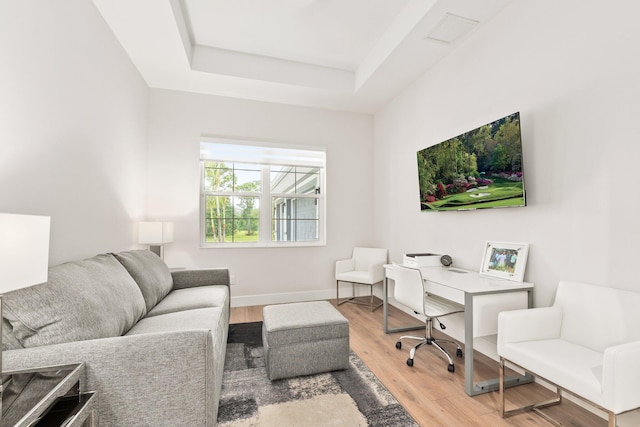 office area featuring hardwood / wood-style floors and a tray ceiling