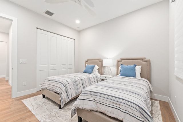 bedroom featuring light wood-type flooring, ceiling fan, and a closet