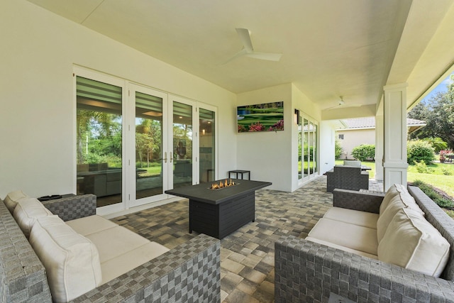 view of patio featuring ceiling fan, an outdoor living space with a fire pit, and french doors