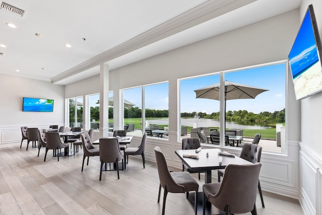 dining area featuring a wealth of natural light, light hardwood / wood-style floors, and crown molding