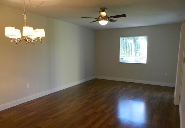 spare room with ceiling fan with notable chandelier and dark hardwood / wood-style flooring