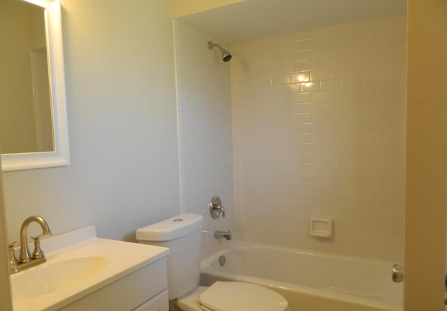 full bathroom featuring tiled shower / bath, vanity, and toilet