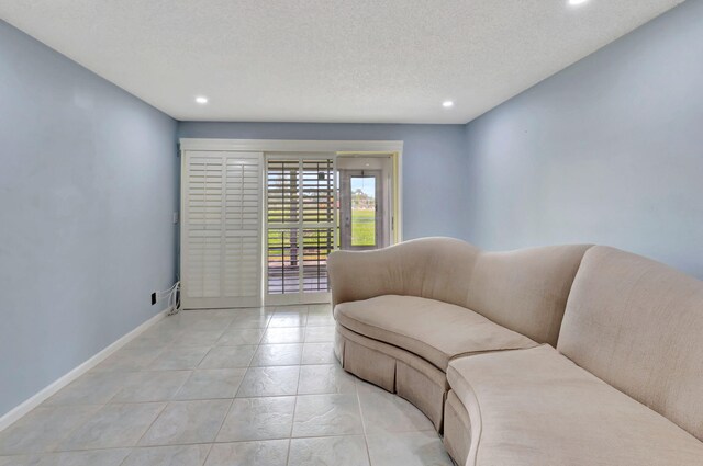 living room featuring a textured ceiling and light tile patterned flooring