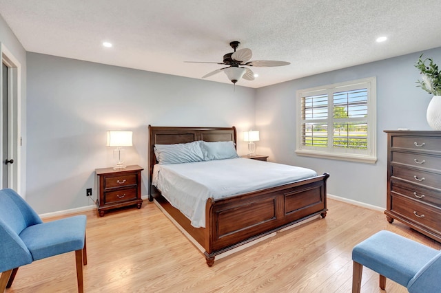 bedroom featuring a textured ceiling, ceiling fan, and light wood-type flooring