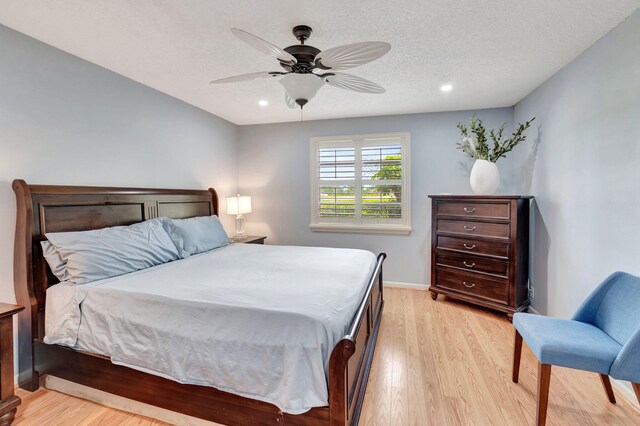 bedroom featuring a textured ceiling, ceiling fan, and light hardwood / wood-style floors