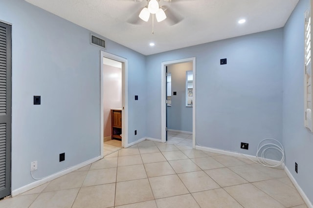 tiled empty room featuring ceiling fan