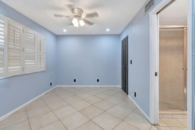 tiled empty room with a textured ceiling and ceiling fan