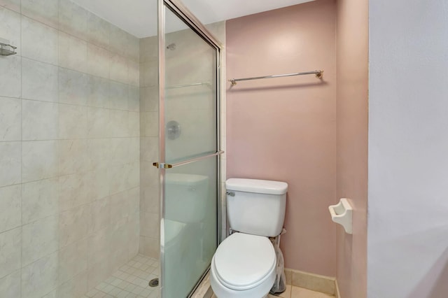 bathroom featuring toilet and a shower with shower door