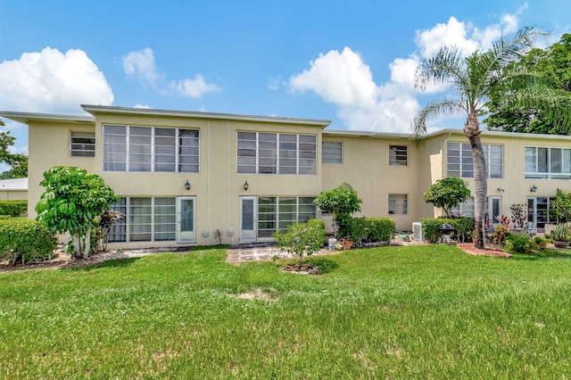 rear view of property featuring a lawn