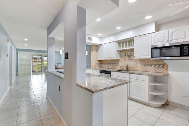 kitchen with white cabinets, light tile patterned floors, appliances with stainless steel finishes, light stone countertops, and ceiling fan