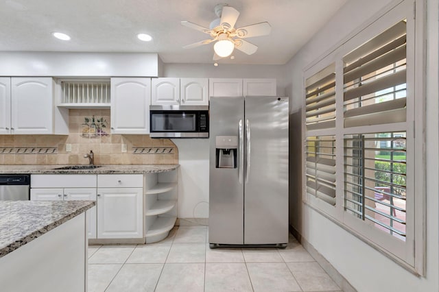 kitchen with white cabinetry, tasteful backsplash, stainless steel appliances, sink, and ceiling fan