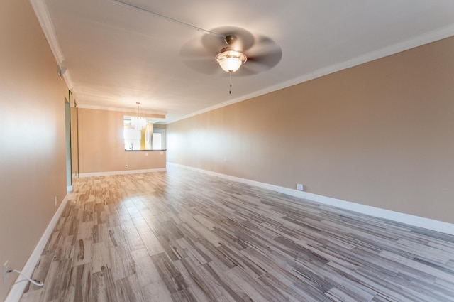 unfurnished room featuring ornamental molding, light wood-type flooring, baseboards, and ceiling fan with notable chandelier