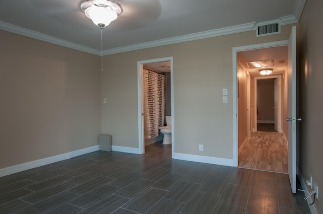 unfurnished bedroom with dark wood-type flooring, a closet, connected bathroom, and ornamental molding