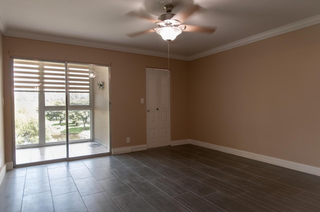 spare room featuring dark wood-style floors, baseboards, ornamental molding, and a ceiling fan