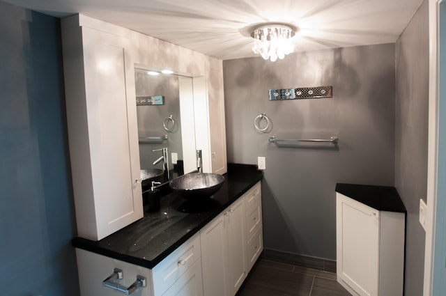 bathroom featuring a notable chandelier, vanity, and baseboards