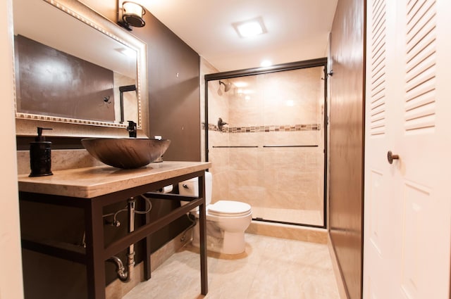 bathroom with a stall shower, vanity, toilet, and tile patterned floors