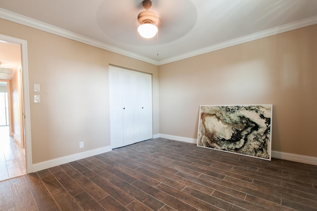 unfurnished bedroom featuring dark wood-style floors, ceiling fan, ornamental molding, and baseboards