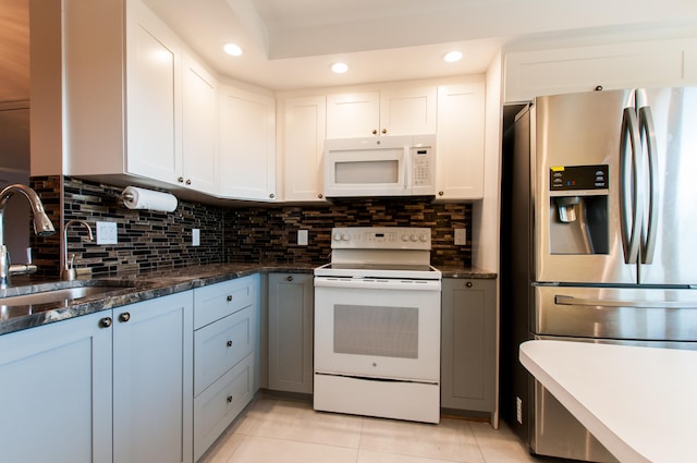 kitchen featuring white appliances, tasteful backsplash, sink, white cabinets, and light tile patterned flooring