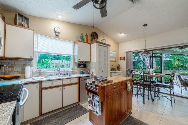 kitchen with ceiling fan, white cabinets, lofted ceiling, hanging light fixtures, and sink