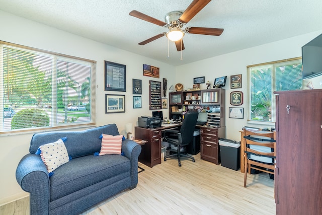 home office with light wood-type flooring, a textured ceiling, and ceiling fan