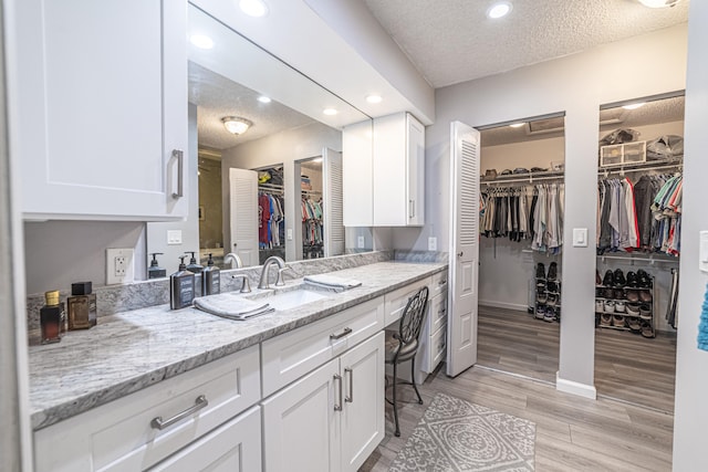 bathroom featuring vanity, a textured ceiling, and hardwood / wood-style floors