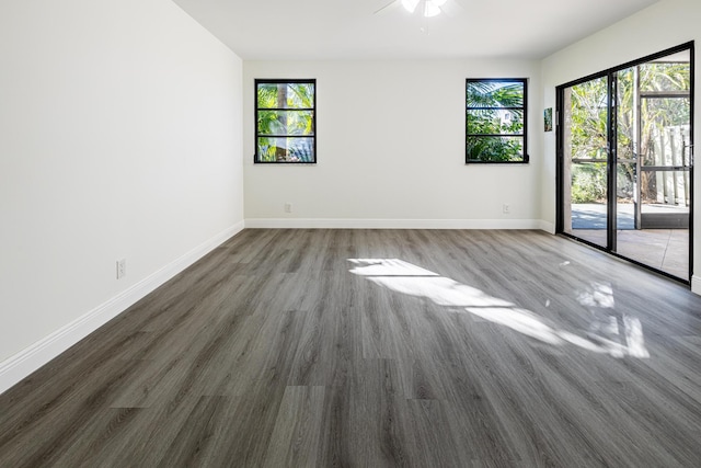 empty room with dark hardwood / wood-style flooring and ceiling fan