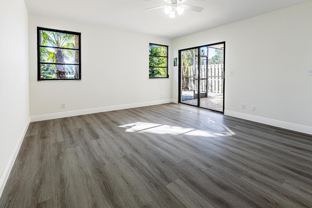 empty room with ceiling fan, dark wood-type flooring, and plenty of natural light