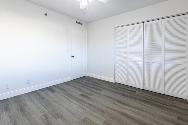 unfurnished bedroom featuring a closet, ceiling fan, and dark wood-type flooring