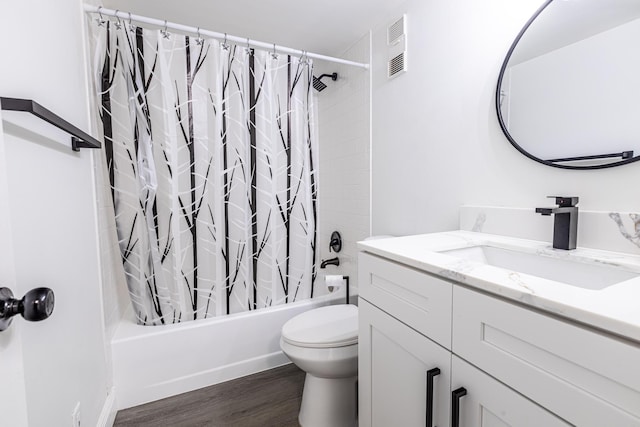 full bathroom featuring hardwood / wood-style floors, vanity, shower / bath combo with shower curtain, and toilet