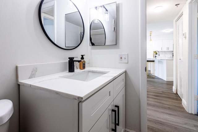 bathroom featuring wood-type flooring, vanity, and toilet