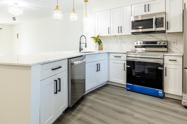 kitchen featuring stainless steel appliances, white cabinetry, light hardwood / wood-style floors, and sink