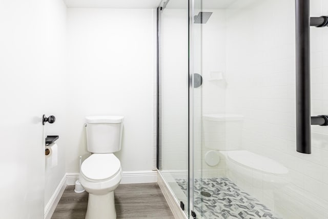 bathroom with walk in shower, hardwood / wood-style floors, and toilet