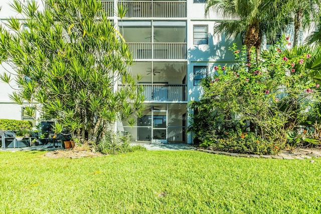 back of house featuring a balcony and a yard