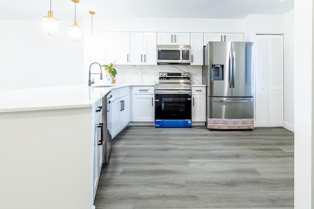 kitchen with light stone counters, white cabinets, sink, light hardwood / wood-style flooring, and stainless steel appliances