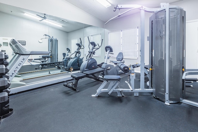 gym with ceiling fan, a textured ceiling, and lofted ceiling