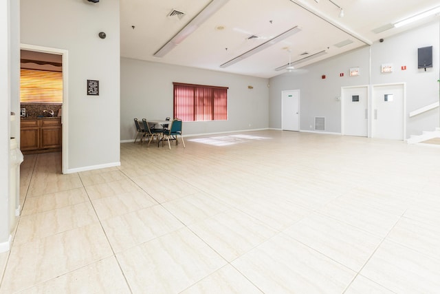 interior space featuring high vaulted ceiling and light tile patterned flooring