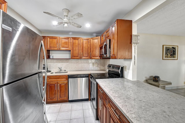 kitchen with tasteful backsplash, light tile patterned floors, stainless steel appliances, sink, and ceiling fan