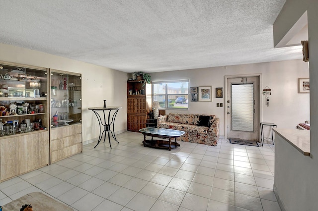 living room featuring a textured ceiling and light tile patterned floors