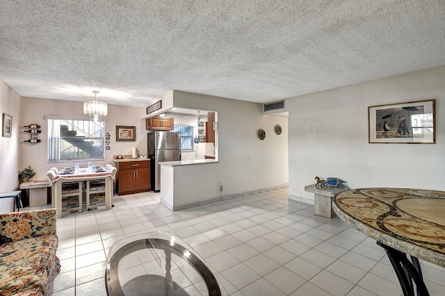 living room featuring a textured ceiling, a wealth of natural light, and light tile patterned flooring