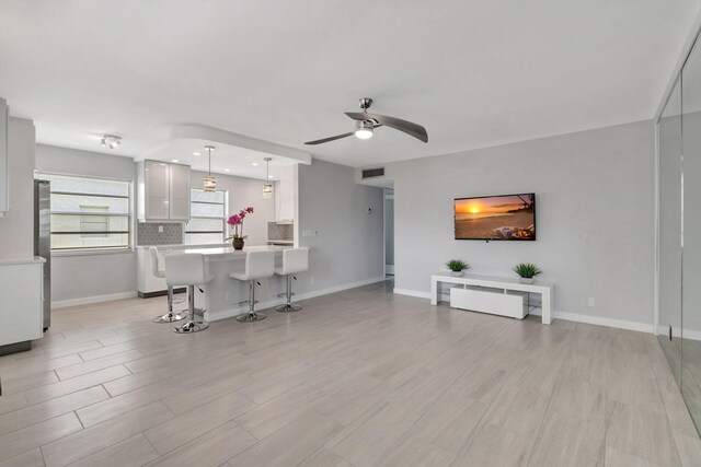 164 Normandy D, Delray Beach, FL 33484 - living room featuring ceiling fan, baseboards, and light wood-style flooring
