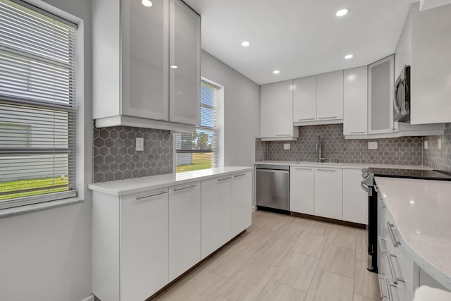 164 Normandy D, Delray Beach, FL 33484 - kitchen featuring white cabinets, tasteful backsplash, appliances with stainless steel finishes, and a sink