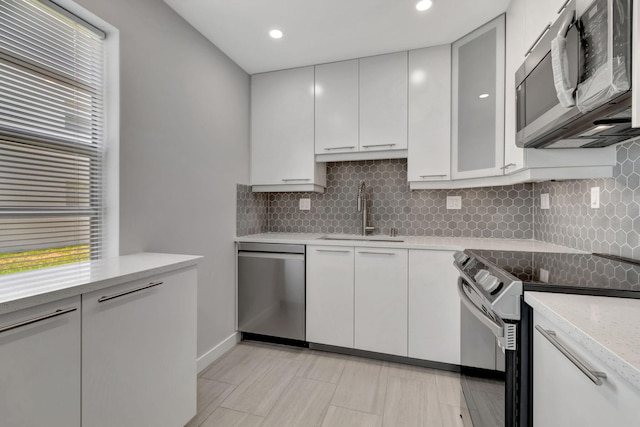 164 Normandy D, Delray Beach, FL 33484 - kitchen featuring backsplash, plenty of natural light, stainless steel appliances, and a sink