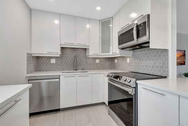 164 Normandy D, Delray Beach, FL 33484 - kitchen with white cabinets, stainless steel appliances, a sink, and backsplash