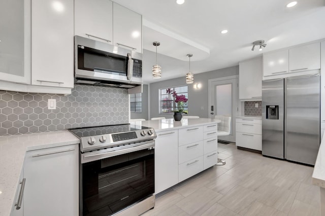 164 Normandy D, Delray Beach, FL 33484 - kitchen with modern cabinets, decorative light fixtures, white cabinets, backsplash, and appliances with stainless steel finishes