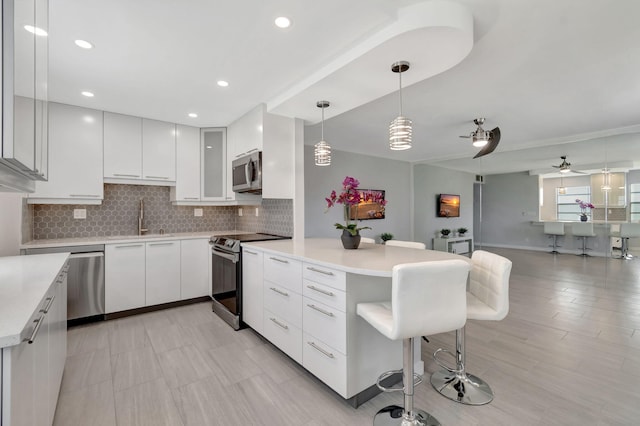 164 Normandy D, Delray Beach, FL 33484 - kitchen with a sink, modern cabinets, stainless steel appliances, a kitchen bar, and backsplash
