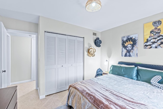 bedroom with light tile patterned floors and a closet